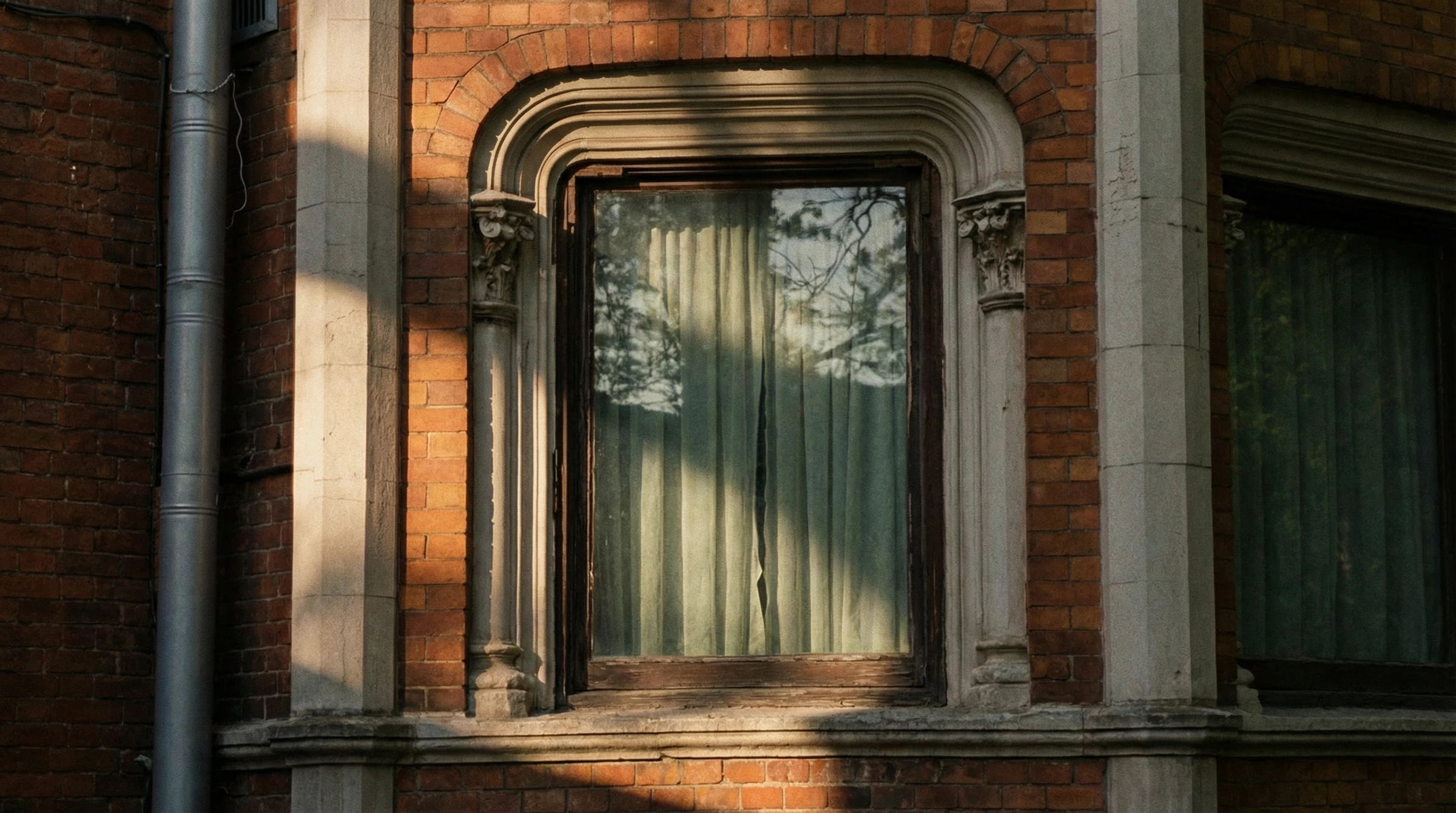 Casa de ladrillo con puerta verde bajo los árboles